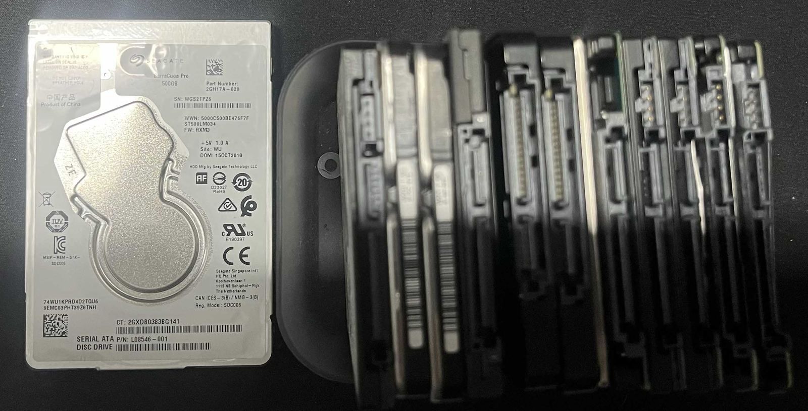 A stack of mechanical hard drives removed from desktops and laptops during repairs.