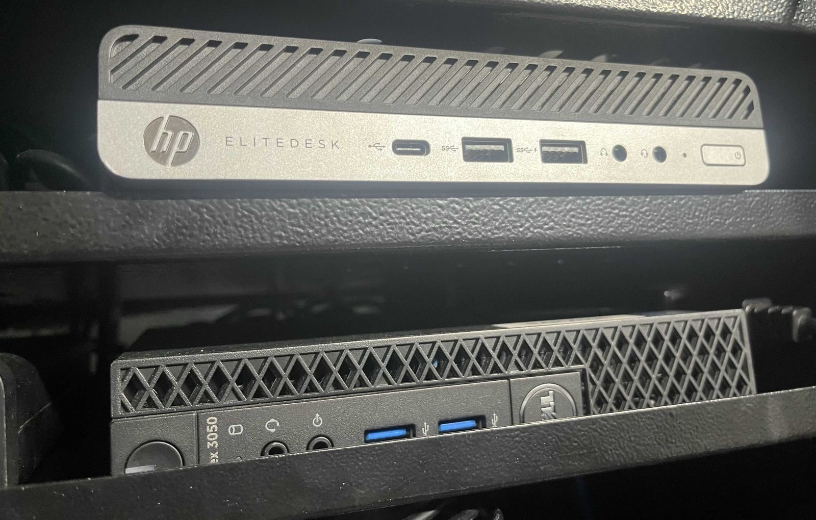 Small-form-factor HP and Dell PCs racked up as a home lab server setup.