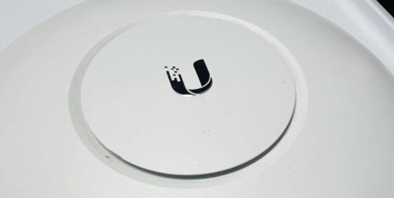 A Ubiquiti UniFi Wi-Fi access point mounted for whole-building coverage.